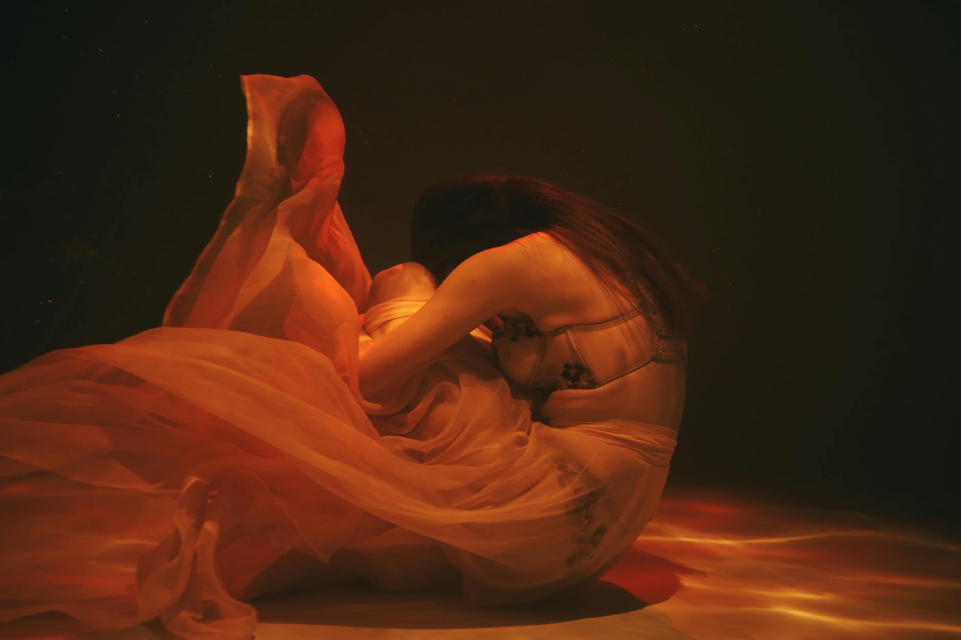 a person curled up underwater
